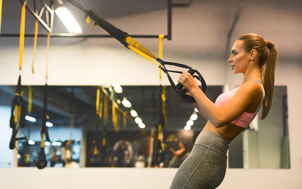 Kobieta na siłowni z Trx Fitness paski - Zdjęcie, obraz