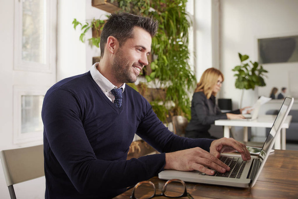 Shot of  financial assistant businessman sitting at office desk and working on laptop - Foto, Imagem