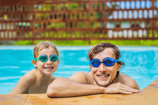 Μπαμπάς και γιος σε κολύμπι γυαλιά να διασκεδάσουν στην πισίνα - Φωτογραφία, εικόνα