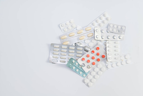 Embalagem de comprimidos e comprimidos sobre fundo branco. Prescrição de medicamentos para tratamento medicamentoso. Medicamento farmacêutico, cura em recipiente para a saúde. Antibiótico, analgésico close-up - Foto, Imagem