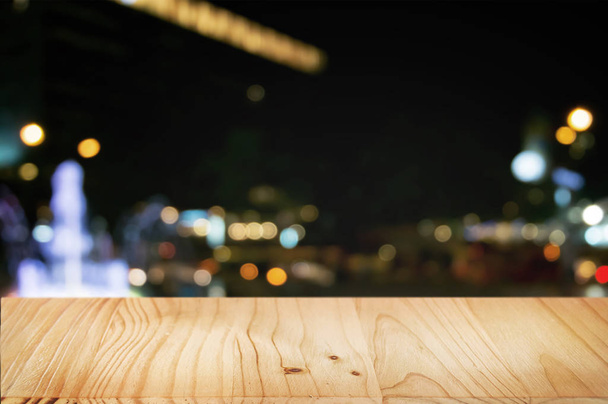 mesa de madera vacía con fondo de mercado nocturno
 - Foto, imagen