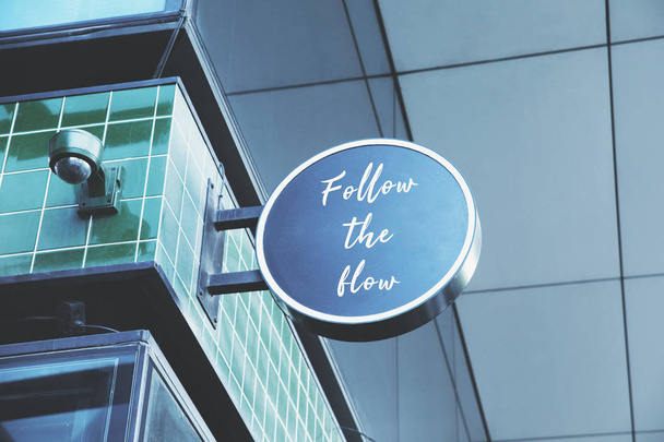 Mirador redondo en la fachada del edificio con letras Follow the Flow
  - Foto, imagen