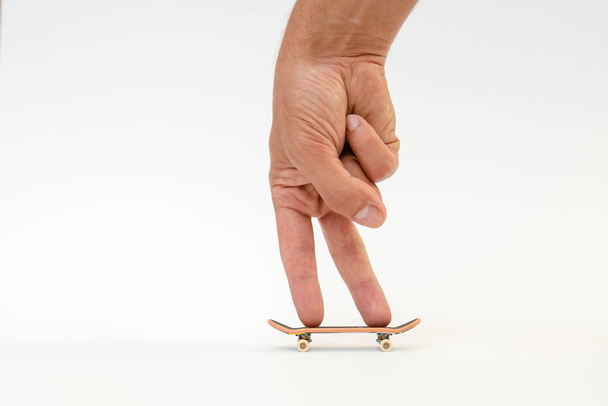 Hmatník. Malý skateboard pro děti a mládež hrát s prsty ruky. Izolované na bílém pozadí - Fotografie, Obrázek