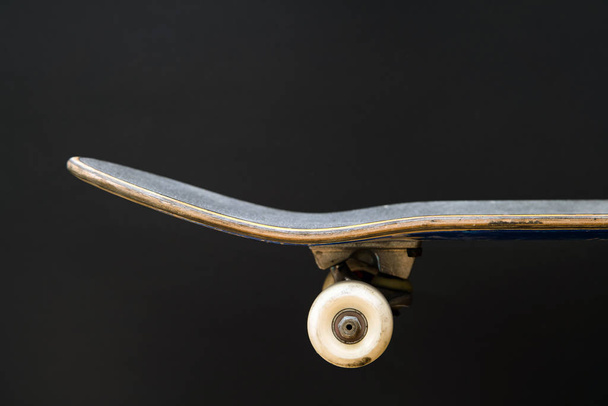 Professionele skateboard op zwarte achtergrond zijaanzicht, dek, volledige installatie, vrachtwagen, dek, wielen - Foto, afbeelding