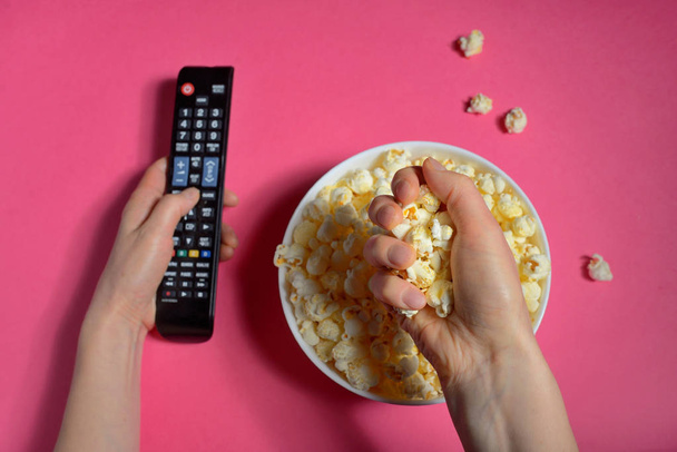 Top view of hands holding remote controller and popcorn bucket isolated - Photo, Image