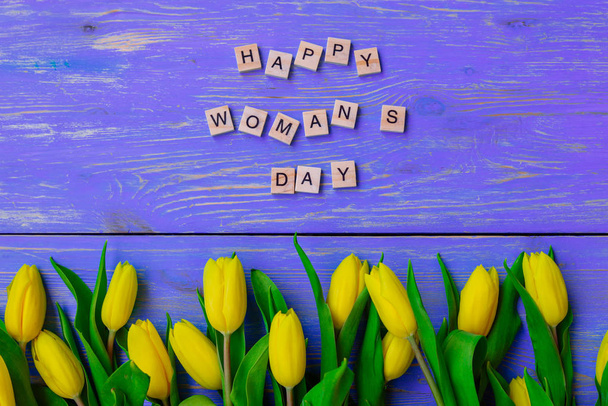 texto del día de la mujer feliz. tulipanes sobre fondo de madera púrpura
 - Foto, Imagen