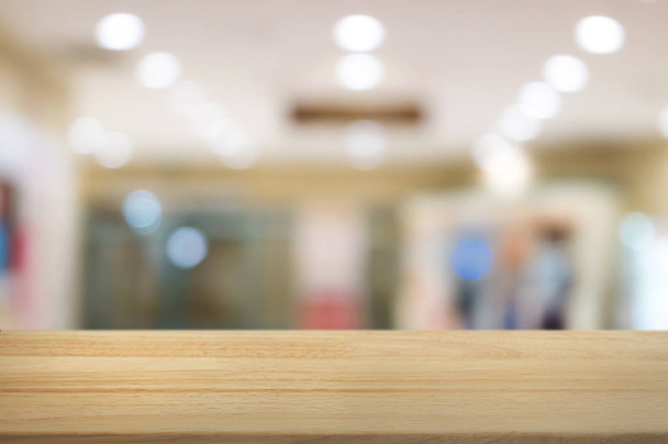 wooden table with montage blurred shopping mall background. - Photo, Image