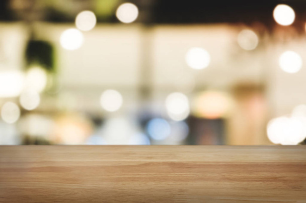 wooden table top in front of blur restaurant background. - Zdjęcie, obraz