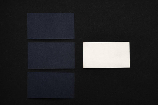 Photo of black blank business cards on a black background. Template for ID. Top view - Foto, afbeelding
