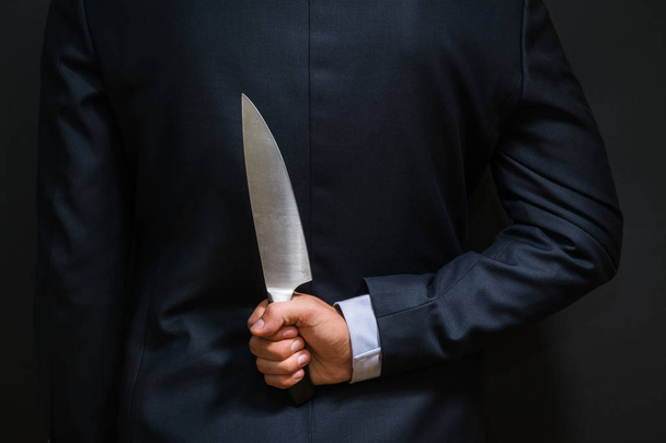 Un criminel avec un gros couteau caché dans son dos. Arme froide, cambriolage
 - Photo, image