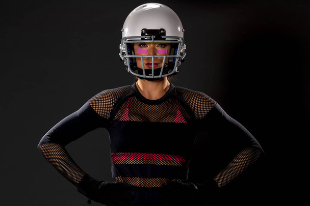 Una hermosa modelo con un casco y sosteniendo un balón de fútbol
 - Foto, Imagen