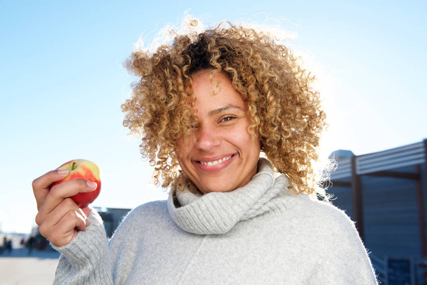 Retrato de cerca de una hermosa mujer afroamericana sosteniendo manzana
 - Foto, imagen