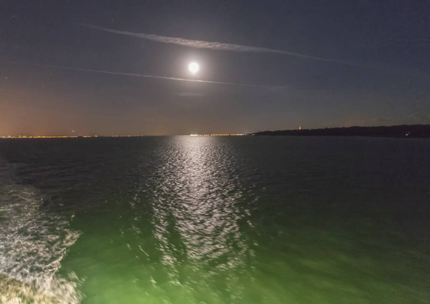 Pełnia księżyca wznosi się nad morze i księżycowy ścieżka - Zdjęcie, obraz