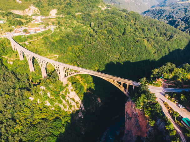Autopista con puente alto a través del cañón. agua clara azul. vista aérea
 - Foto, imagen