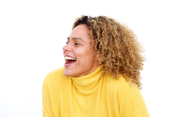 Retrato de cerca de una joven afroamericana con el pelo rizado riéndose contra un fondo blanco aislado
 - Foto, Imagen
