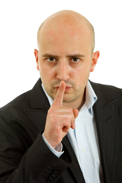 jonge man stilte gebaar met zijn vinger in de mond tonen - Foto, afbeelding