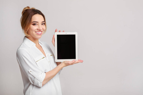 Cheerful woman showing display of tablet computer - Photo, Image