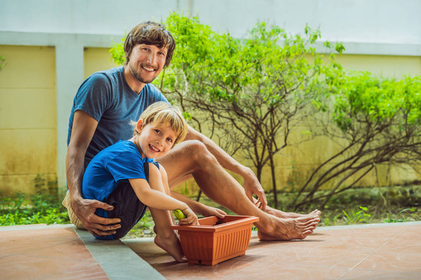 Father and son gardening in the garden near the house - Photo, image