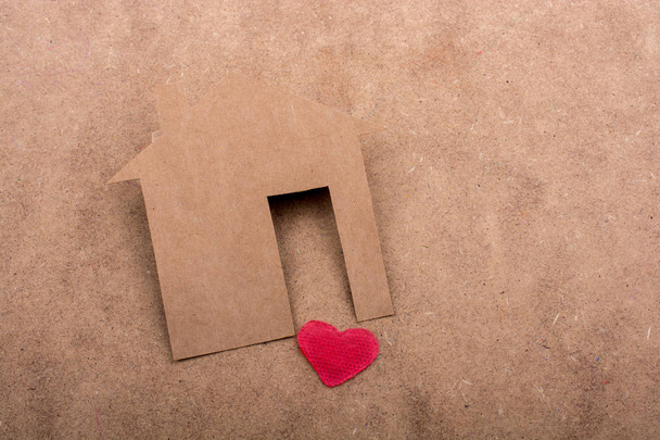 Маленький дом, вырезанный из бумаги, и сердце на холсте - Фото, изображение