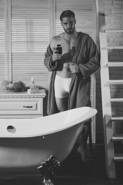 Macho with muscular torso in underwear and bathrobe at bath - 写真・画像