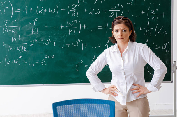 Female math teacher in front of the chalkboard  - Φωτογραφία, εικόνα