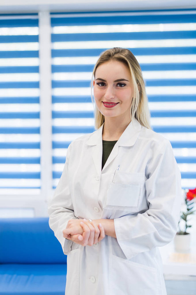 Young female doctor or nurse standing at hospital reception - Valokuva, kuva