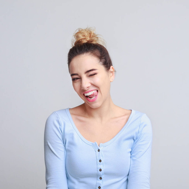 Funny girl winking and showing tongue over background - Photo, Image