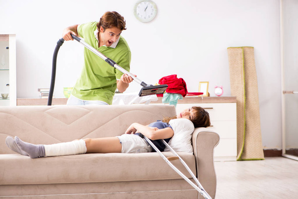 Esposo ayudar pierna lesionada esposa en las tareas domésticas
 - Foto, Imagen