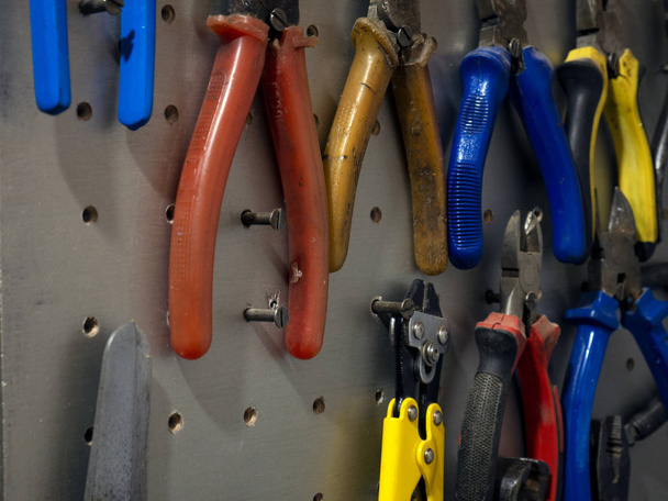Muitas ferramentas coloridas no estande na oficina
 - Foto, Imagem