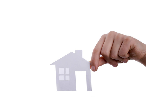 Hand holding an isolated paper house with a white background - Photo, Image