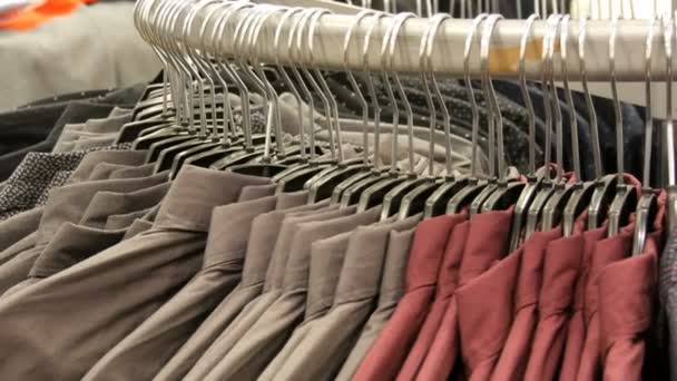 Row of various fashionable mens shirts on a huge hanger in the mens clothing store in the shopping center. - Footage, Video