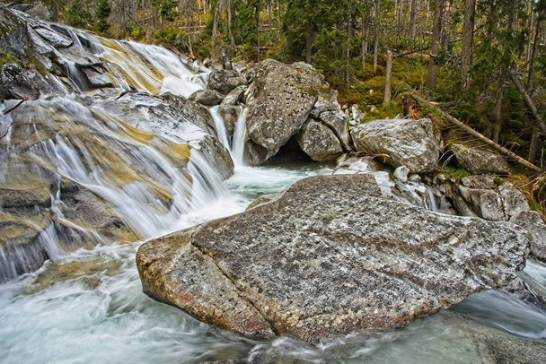 高タトラ山脈の冷たいきしみ滝。長い滝の滑らかな水コース. - 写真・画像