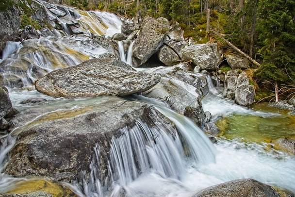 Koude luidspreker watervallen in de Hoge Tatra gebergte. Gladde water paden van lange waterval. - Foto, afbeelding