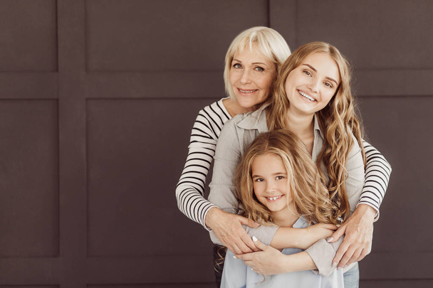 Три поколения счастливых женщин смотрят в камеру
 - Фото, изображение