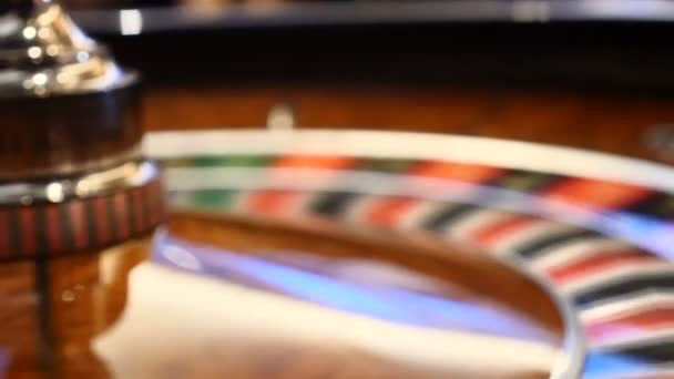 Detailní záběr rozostřeného kasino ruleta otočila s kasino, který čipy do hromady poblíž. Smůly a štěstí koncepce. Kolo rulety běží. Město nočních... hazardní hry lidé - Záběry, video