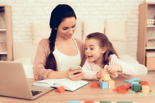 Happy Little Girl and Mother with Phone at Home. - Foto, immagini
