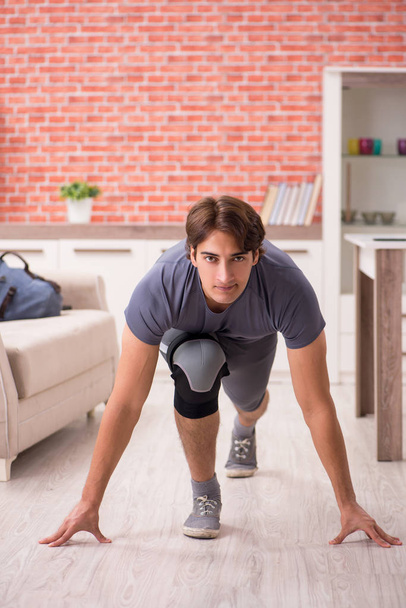 Young handsome man doing sport exercises at home  - 写真・画像