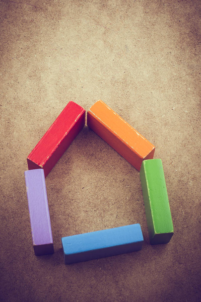 House shape formed out of building blocks on a brown background - Photo, Image