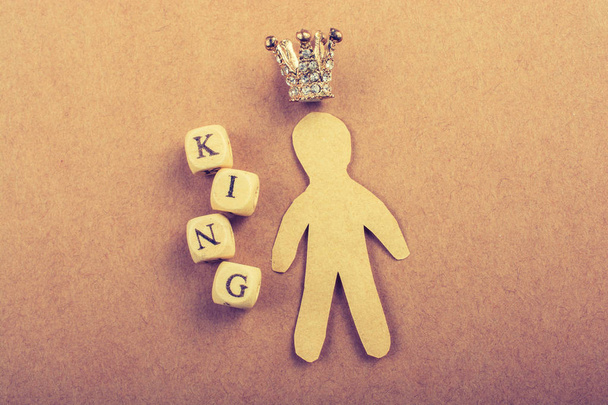 Pieni malli kruunu vieressä kuningas sanamuoto ruskea - Valokuva, kuva
