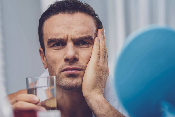Nice handsome man holding a glass of water - Foto, afbeelding
