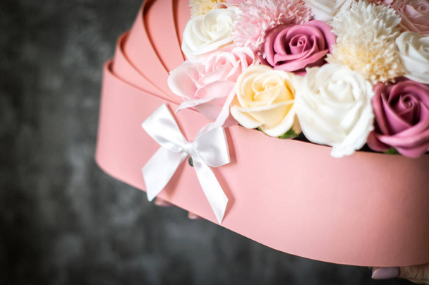 Congratulations on the birth of the baby: Pink box with multi-colored flower buds in the form of a baby cot. - Foto, Imagem