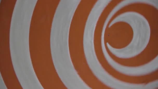 orangefarbenes hypnotisches Rad aus nächster Nähe. Hypnose-Spiralen sind eine Möglichkeit, in Trance einzutreten oder Hypnose-Skripte zu verwenden. hypnotische Wirkung, die erreicht wird, während sich die Scheibe dreht. Optische Täuschung bewegte Scheibe - Filmmaterial, Video