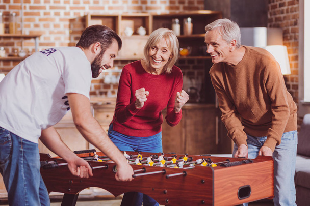 Pensionista inspirado jugando un juego con un hombre joven
 - Foto, Imagen