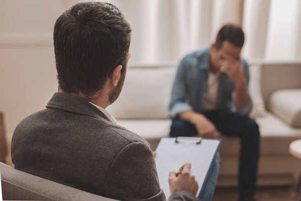 Professional psychologist providing help his stressed client - Фото, зображення