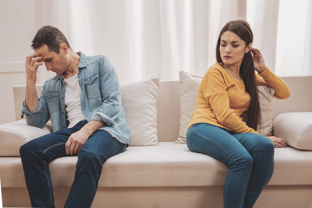 Young wife feeling disillusioned sitting near lying husband - Photo, Image