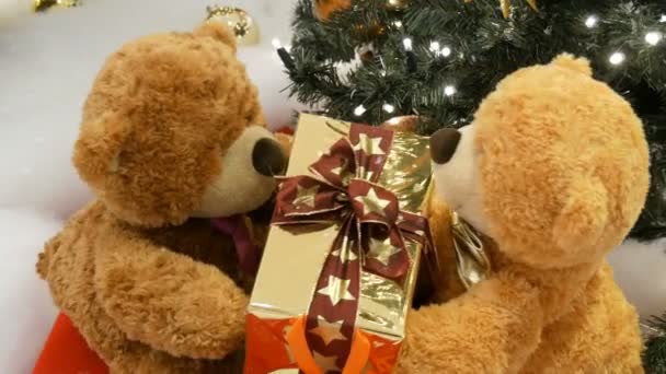 Lustige braune bewegliche Teddybären, die eine Schachtel mit einem Geschenk in ihren Pfoten halten. Weihnachtsdekoration in Einkaufszentrum - Filmmaterial, Video
