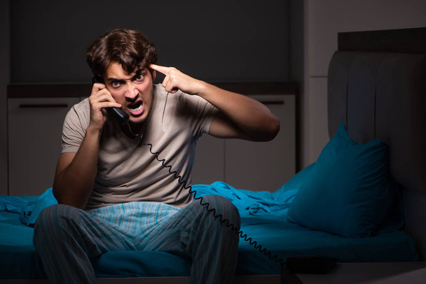 Young man talking on phone in bed - Photo, Image