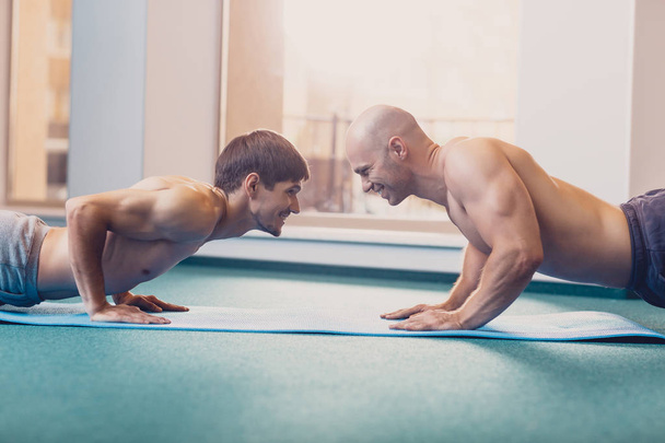 Due uomini eseguiranno un allenamento fitness in palestra
 - Foto, immagini