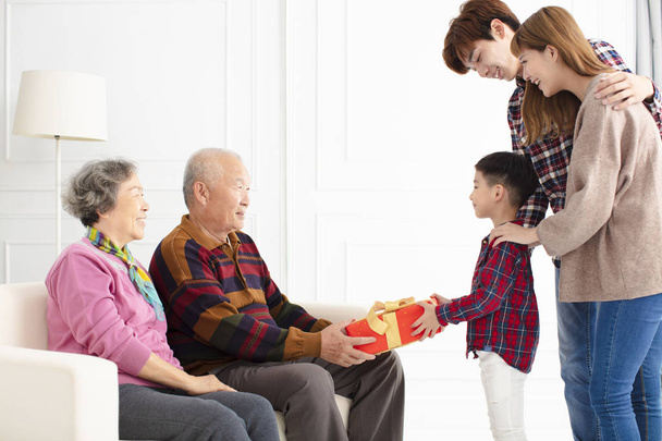 neto com pais dando um presente aos avós
 - Foto, Imagem