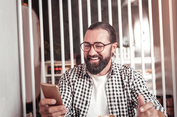 Az ember a kávézóban ülve egy okostelefon segítségével - Fotó, kép